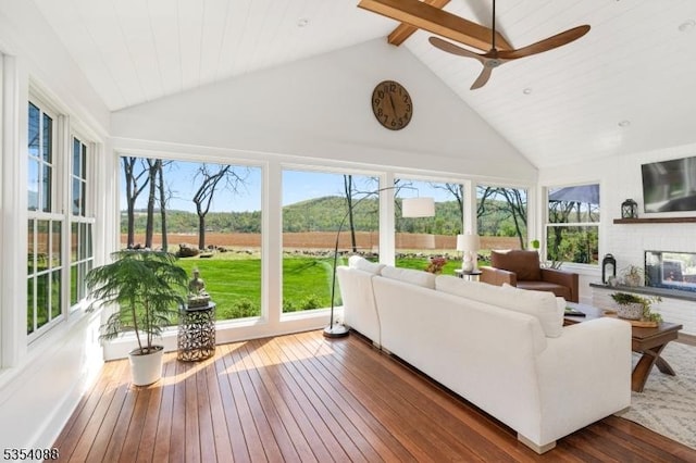 sunroom with wood-type flooring, beam ceiling, and high vaulted ceiling