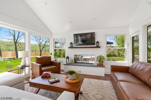 sunroom featuring lofted ceiling, wood finished floors, and a wealth of natural light