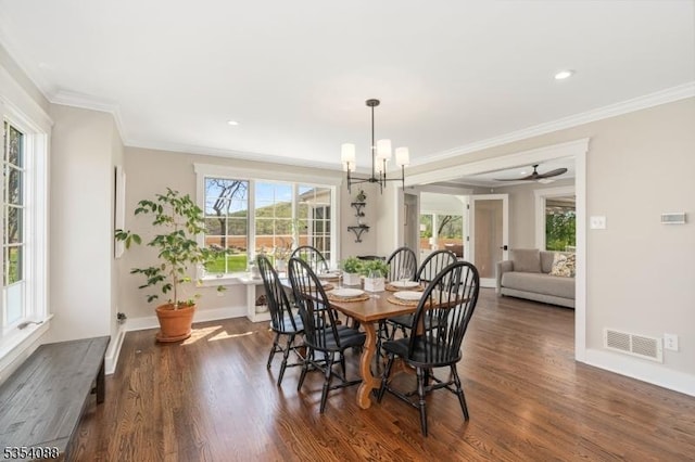 dining room featuring crown molding, baseboards, visible vents, and wood finished floors