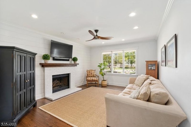 living room with ceiling fan, a fireplace, recessed lighting, dark wood-type flooring, and ornamental molding