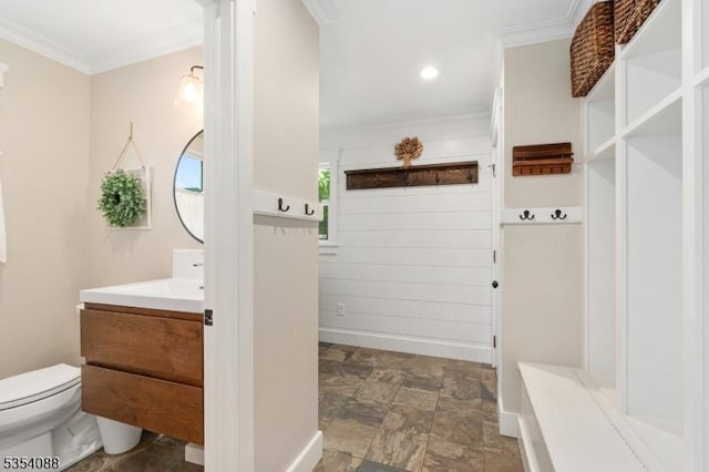 mudroom featuring crown molding, stone finish floor, and baseboards