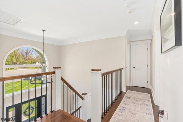 hall with visible vents, wood finished floors, an upstairs landing, ornamental molding, and recessed lighting
