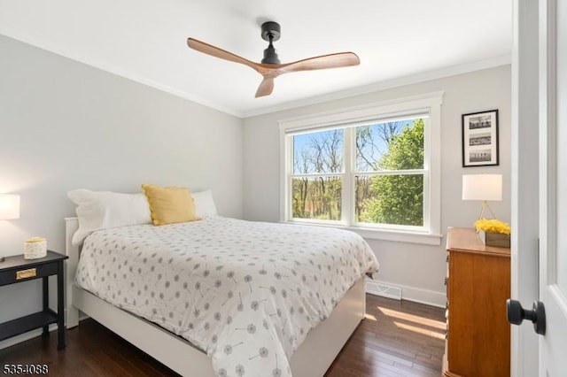 bedroom featuring baseboards, ornamental molding, dark wood-style flooring, and visible vents