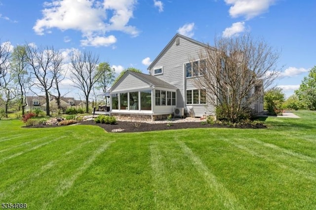 back of house featuring a yard and a sunroom