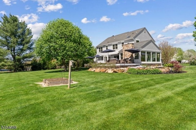 back of property featuring a lawn and a sunroom