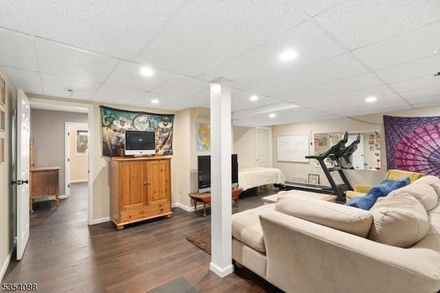 living area with baseboards, dark wood-style flooring, and a paneled ceiling