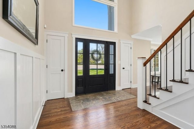 foyer featuring stairs, a high ceiling, and wood finished floors