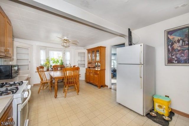 kitchen featuring ceiling fan, brown cabinets, light countertops, light floors, and white appliances