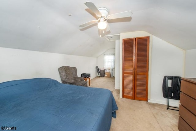bedroom with a closet, light carpet, baseboards, ceiling fan, and vaulted ceiling