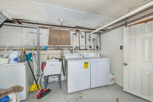 washroom featuring a sink, laundry area, and washing machine and dryer