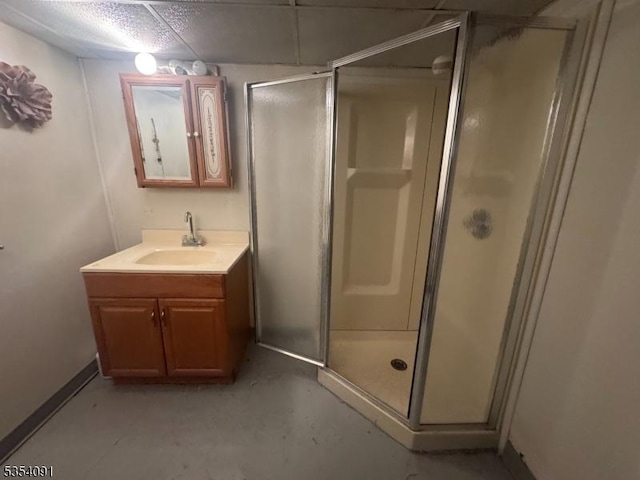 full bathroom with vanity, baseboards, a stall shower, and concrete floors