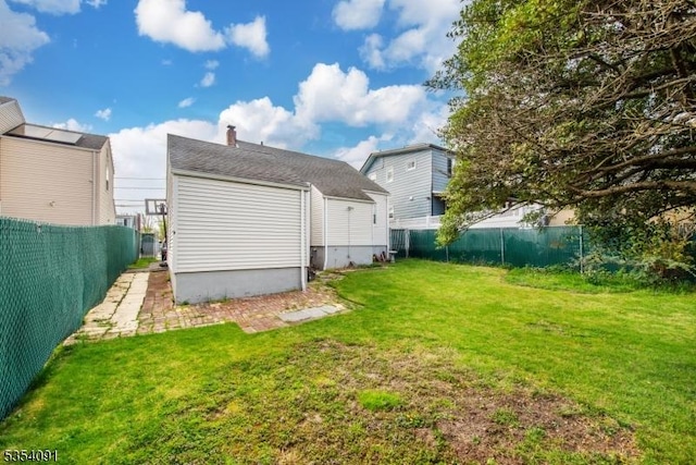rear view of property featuring a lawn, a fenced backyard, and a chimney