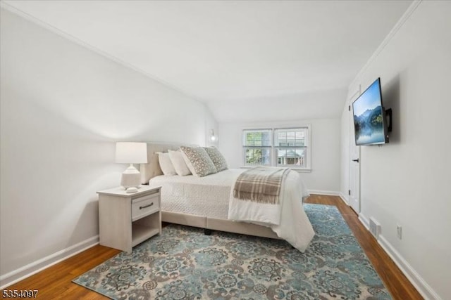 bedroom featuring visible vents, baseboards, and wood finished floors