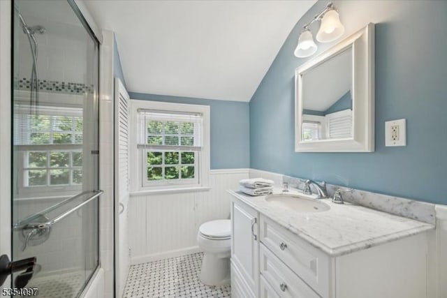 full bathroom featuring toilet, vaulted ceiling, wainscoting, and vanity