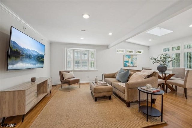living room with light wood finished floors, recessed lighting, baseboards, a skylight, and ornamental molding