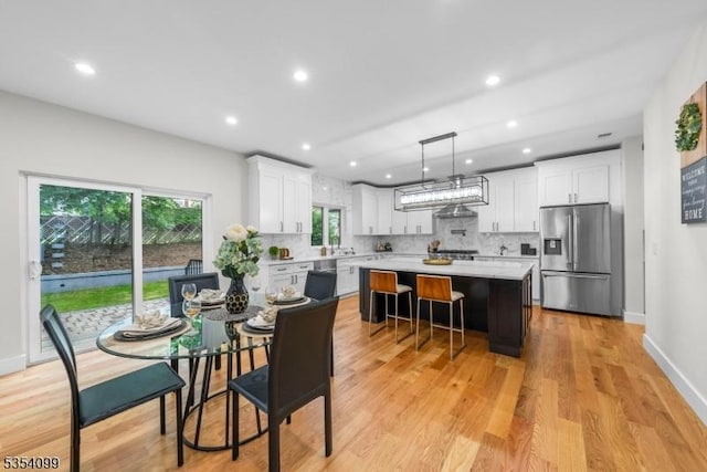 dining area featuring light wood-type flooring, recessed lighting, and baseboards