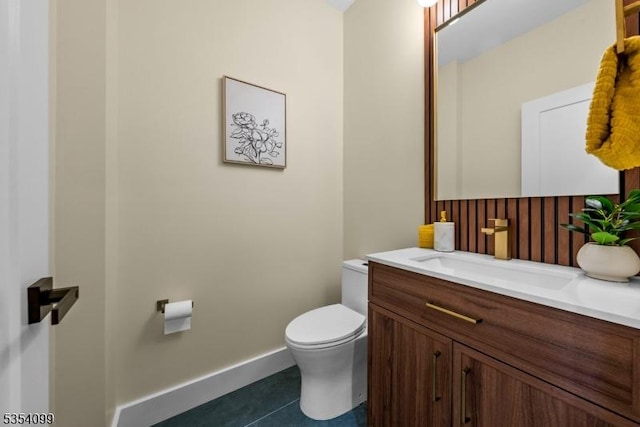 half bathroom featuring tile patterned flooring, toilet, vanity, and baseboards