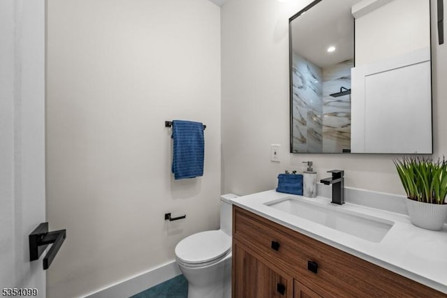 full bathroom with toilet, vanity, a shower, and baseboards