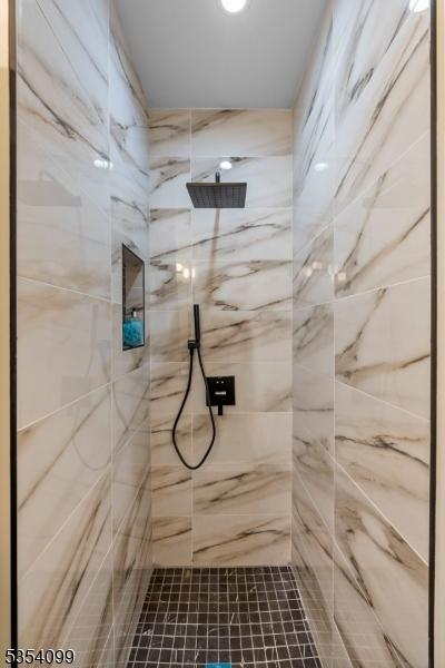 full bathroom featuring a marble finish shower