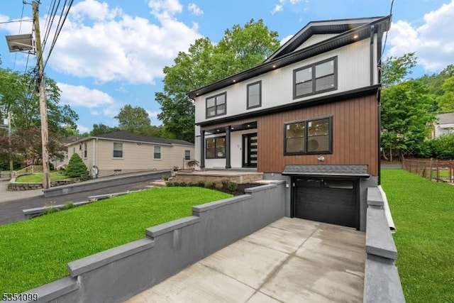 view of front of home with a garage, driveway, and a front lawn