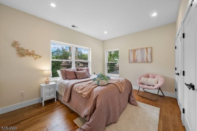 bedroom with light wood-style flooring, baseboards, recessed lighting, and a closet