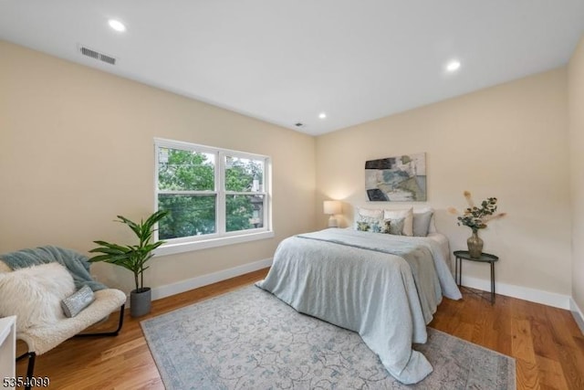 bedroom featuring baseboards, wood finished floors, and recessed lighting