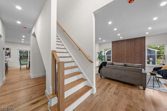 stairs with recessed lighting, wood finished floors, and baseboards