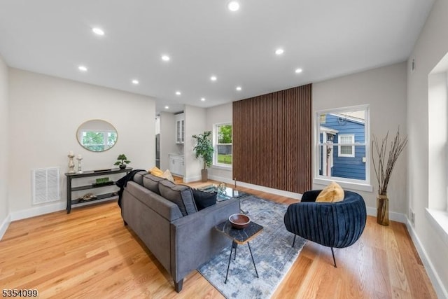 living area with light wood-style floors, baseboards, and recessed lighting