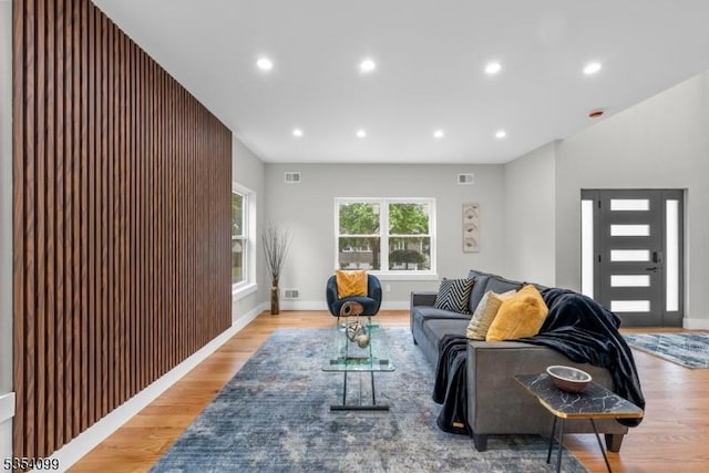 living area with light wood-type flooring, recessed lighting, and baseboards