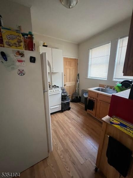 39 Prospect St Unit 4, Bloomfield Twp, NJ 07003 - kitchen with white appliances, light wood-type flooring, a sink, and radiator heating unit
