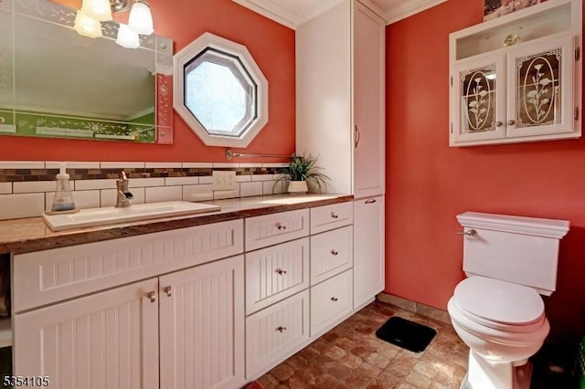 bathroom featuring vanity, decorative backsplash, and toilet