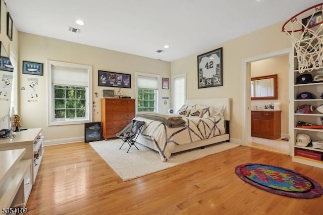 bedroom featuring visible vents, light wood-style floors, baseboards, and multiple windows