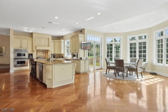 kitchen with cream cabinets, stainless steel appliances, plenty of natural light, and wine cooler