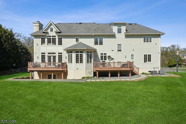 back of property with a lawn, a wooden deck, and a chimney