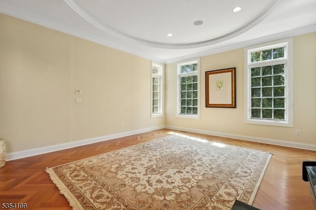 unfurnished room featuring ornamental molding, a raised ceiling, and a healthy amount of sunlight