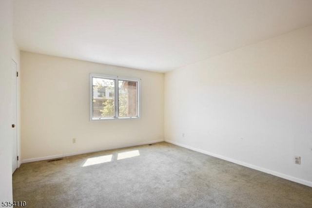 unfurnished room featuring carpet floors and baseboards