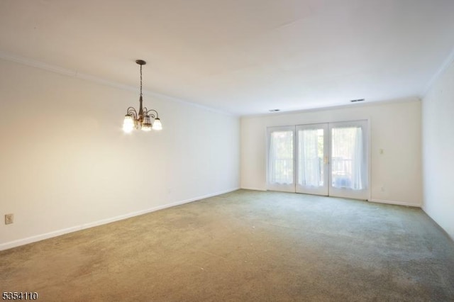 carpeted empty room with crown molding, baseboards, and a chandelier