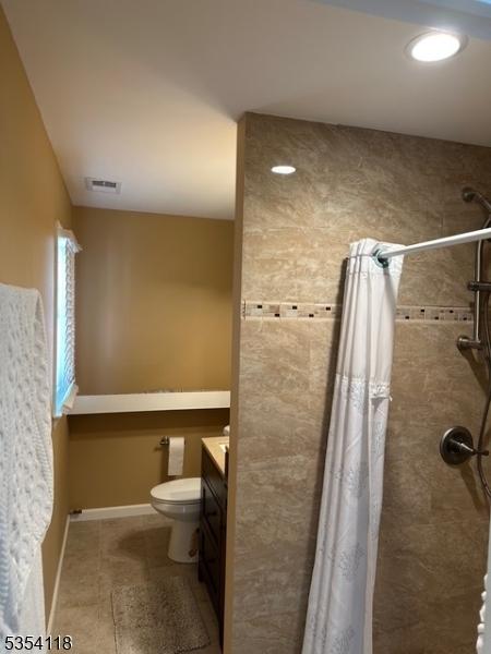 61 Duval St, Bridgewater Twp, NJ 08807 - bathroom featuring vanity, visible vents, toilet, tiled shower, and tile patterned floors