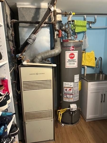 61 Duval St, Bridgewater Twp, NJ 08807 - utility room featuring water heater and a sink