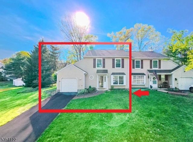 view of front facade featuring a garage, aphalt driveway, and a front yard