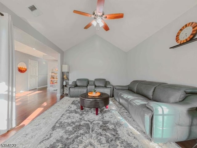 living room featuring ceiling fan, visible vents, wood finished floors, and lofted ceiling