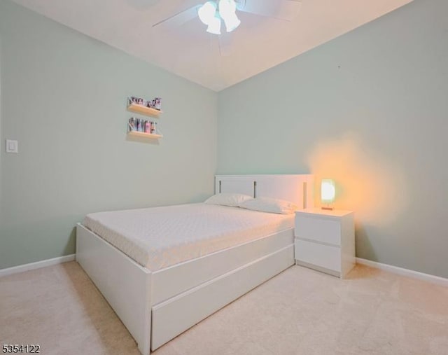 bedroom with a ceiling fan, baseboards, and light colored carpet