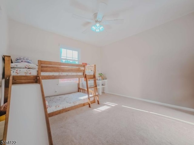 carpeted bedroom featuring baseboards and a ceiling fan