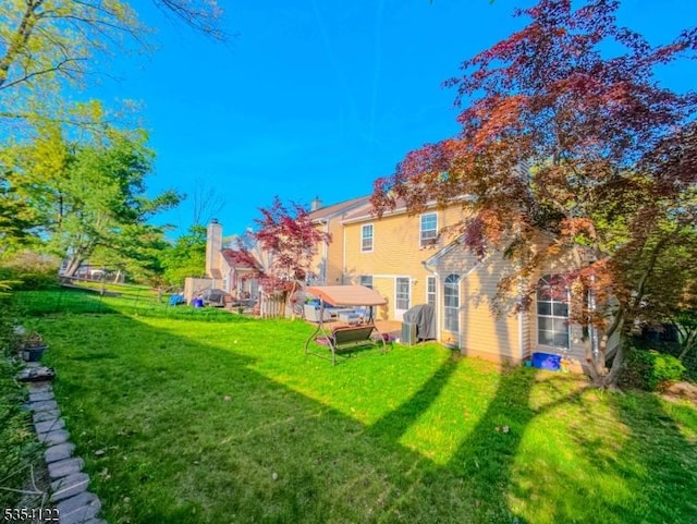 back of property with fence and a yard