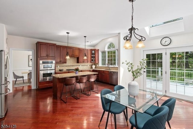 dining room featuring dark wood-style flooring and lofted ceiling with skylight