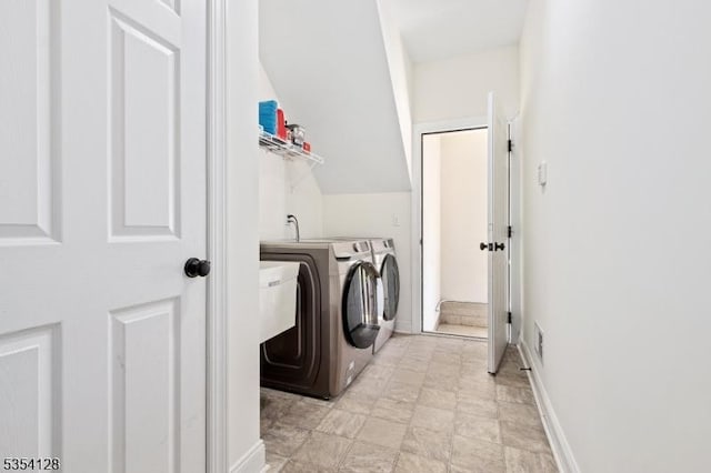laundry area with laundry area, baseboards, and washer and dryer