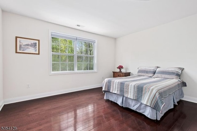 bedroom with visible vents, baseboards, and hardwood / wood-style flooring