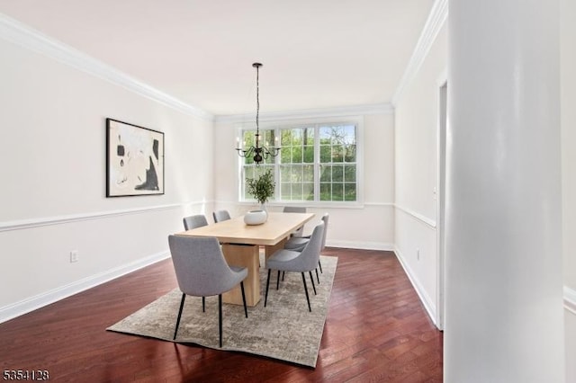 dining room with crown molding, dark wood-style flooring, baseboards, and a chandelier