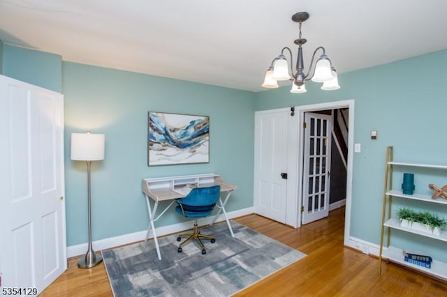 office area with baseboards, wood finished floors, and a chandelier