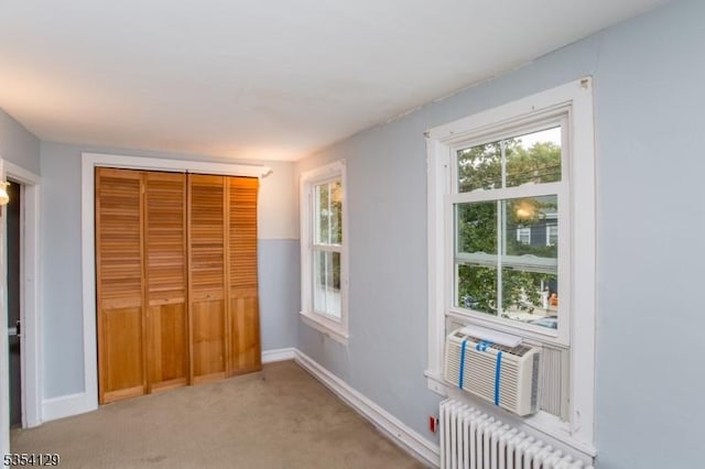interior space featuring radiator heating unit, baseboards, a closet, and light colored carpet